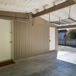 The attached carport with garage door provides a storage closet and easy access into the kitchen for groceries. 
