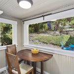 The kitchen flows out to the sunroom/eating nook with a lush green view of the back yard and gardens.