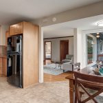 The living room flows into the spacious updated kitchen with eating space, flooded with light from walls of windows on three sides, including a sliding door out to...