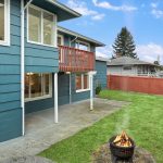 Fully-fenced, terraced backyard with patio and barbeque area. 