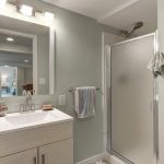 The newly updated 3/4 bath features a window for natural light, a new toilet, vanity, LED lighting, hardware, luxury vinyl plank flooring, and plenty of original built-in shelving.  