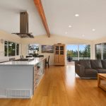 Large open Chef’s Kitchen, living, and dining rooms showcase the views, flooded in the natural light from walls of windows and vaulted ceilings.