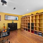 The lower northeast bedroom number five has newer high-quality hardwood flooring and a newer widened window for more natural light. This room was most -recently used as an executive music director's office. The shelving is included with sale.
