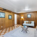 The room features warm tones of real wood paneling. A wonderful place for a theater or entertainment center.  