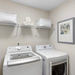 The generous laundry room features new luxury vinyl flooring and LED lighting for an inviting atmosphere. The brand-new washer and dryer promise efficiency and convenience, making laundry a breeze. 