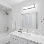 Step into the beautifully-updated bathroom, where every detail has been carefully considered. The new quartz countertop, bottom-mount sink, and sleek faucet add a touch of modern elegance. The tiled shower surround and hardware create a spa-like experience, while LED lighting illuminates the space. Underfoot, luxury vinyl flooring ensures both style and practicality, all designed with accessibility in mind.