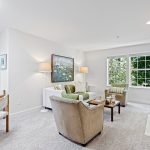 Step into the living room, where nature paints a lush green vista beyond the windows. As an end unit, abundant natural light floods the space, creating a warm and inviting ambiance. 