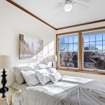 The cozy bedroom is bathed in natural light throughout the day, thanks to its wall-to-wall, south-facing window, offering serene city views and breathtaking sunsets to unwind by.