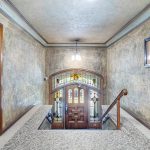 The inviting lobby exudes timeless elegance, with impeccably maintained millwork, stunning stained-glass Art Deco details, a cozy fireplace, and a classic gated elevator that whispers of a bygone era.