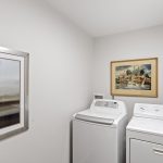 Bright and efficient laundry space with full-size washer and dryer.