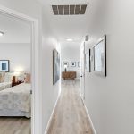 Bright hallway connects the bedrooms to the main living space, with a peek into the charming secondary bedroom.