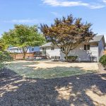 Expansive lawn and thoughtful landscaping create a welcoming backdrop.