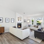 Skylit living room with vaulted ceilings, gas fireplace, and fresh white trim for a bright, airy feel.