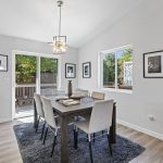 Dining area with vaulted ceiling and modern pendant lighting, overlooking the backyard.