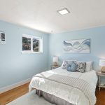 Peaceful bedroom with hardwood floors and a south-facing window for light throughout the day.