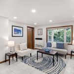 The main seating area is simple, cozy, and framed by greenery just outside—privacy and nature without giving up convenience.