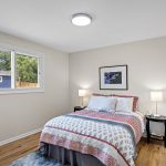North bedroom overlooks the backyard with a wide western view—sunlight all afternoon and newly refinished oak floors underfoot.
