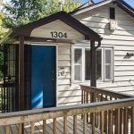 The upper-level unit enjoys a private, elevated entry—tucked behind trees, with a sunny front porch overlooking the street.