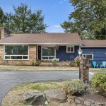 Classic mid-century charm with sandstone planter beds, layered textures, and vinyl windows with future upgrade potential.
