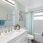 Fully updated full bath with new vanity, fixtures, LVP flooring, and ceiling-height subway tile—clean, calm, and timeless.