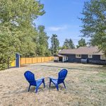 The upper terrace forms a natural gathering space, centered around a fire pit and surrounded by mature trees and dappled shade—a peaceful perch for outdoor connection.