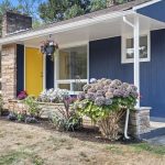 Hydrangeas, stone-faced planter beds, and layered textures brighten the entry path.