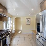 A view back toward the entry highlights tile floors, recessed lighting, and the welcoming layout of the upper unit.