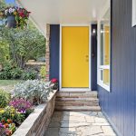Covered flagstone walkway with classic sandstone and cheerful blooms—an inviting approach that sets the tone for home.