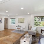 Open layout with space to gather, dine, or unwind—set against a backdrop of treetops and sky.