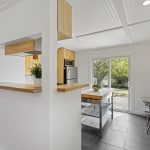 This is the hinge of the house: dining space, extra prep surface, and a sliding door that makes the deck feel like the next room.