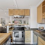 Storage goes vertical: full-height cabinetry, deep drawers, open cubbies and glass-front uppers put nearly every inch to work.
