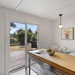 The kitchen ends at the slider. From here, the house hands off to the deck, yard and everything beyond.