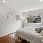 The main bedroom looks south across the backyard—a peaceful vista of mature trees, open sky and the grounds beyond.