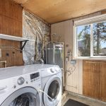 Outside the living area, this clean, dry, secure utility room adds the kind of support space a small house needs: daylight, included front-loading washer and dryer, plus included shelving and room for storage.