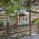 A little house with a surprisingly full sense of place—mature trees, a fenced front garden and its own patch of Hillman City.