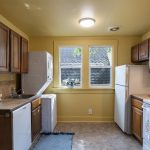 The upper kitchen keeps in-unit laundry tucked beside the sink.