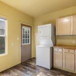 East-facing kitchen catches the morning light, with in-unit laundry and a separate door directly to the backyard.