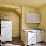 A walk-in pantry/storage closet just beyond the refrigerator adds substantial kitchen storage.