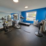 The clubhouse fitness center includes cardio and strength equipment, free weights, and a portable air conditioner for added comfort.
