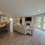 From the kitchen, the open pass-through looks directly into the spacious dining and living area—easy for serving, conversation, and keeping everyone connected.