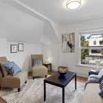Unit A – Upper: street-facing living room with a broad front window.